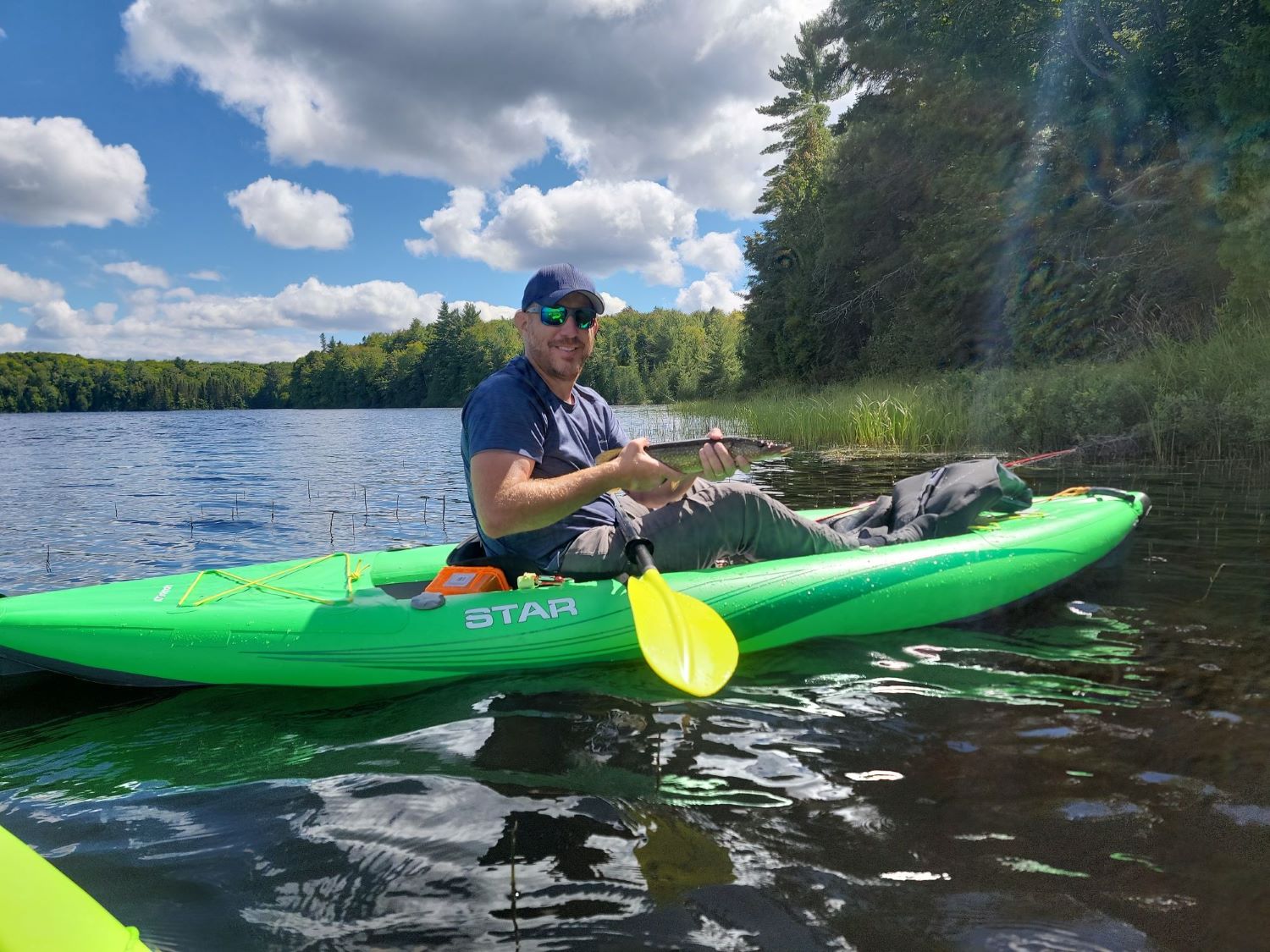 Luke fishing from a kyak holding a big fish