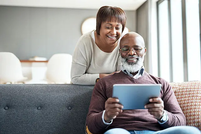 A couple looks at an iPad in their home