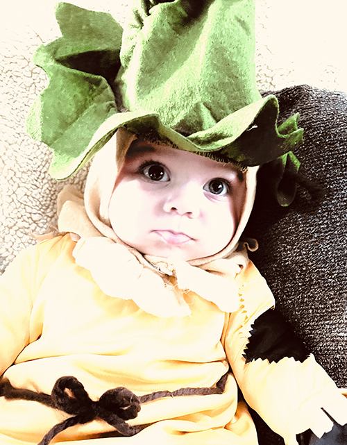 A baby dressed in a scarecrow costume